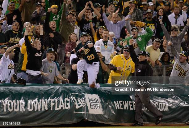 Third base umpire Phil Cuzzi raises his arm with the out sign after Josh Donaldson of the Oakland Athletics dove over the tarp catching a foul ball...