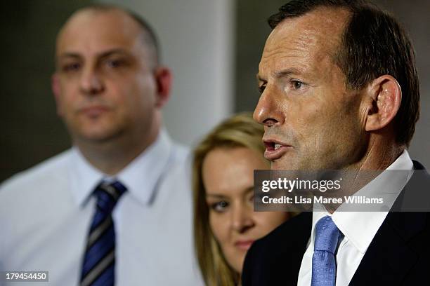 Australian Opposition Leader, Tony Abbott speaks to the media as Liberal candidate Fiona Scott looks on, on September 4, 2013 in Sydney, Australia....