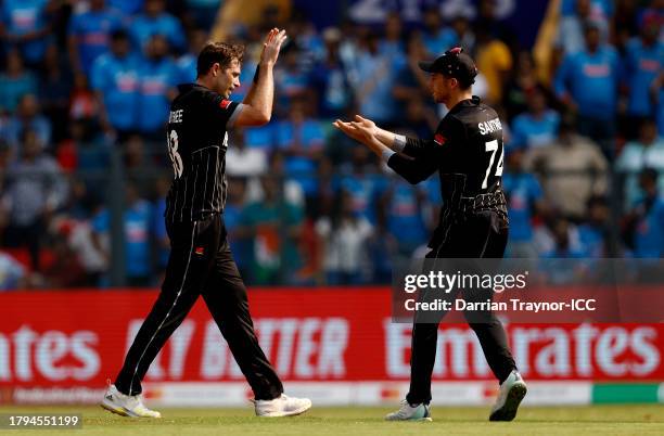 Tim Southee of New Zealand celebrates with teammate Mitchell Santner after dismissing Rohit Sharma of India during the ICC Men's Cricket World Cup...