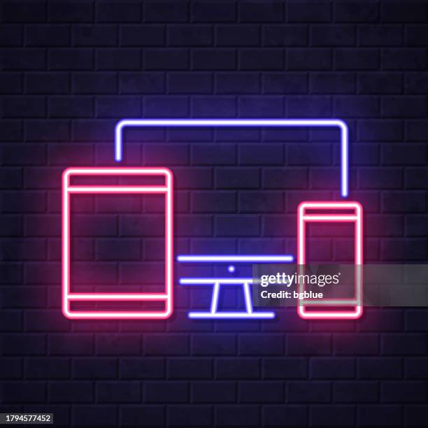 desktop computer, tablet pc and smartphone. glowing neon icon on brick wall background - touch screen wall stock illustrations