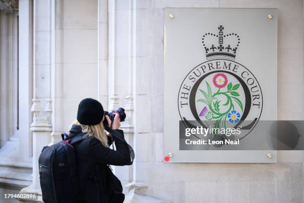 Photographer takes an image of the building signage as people wait for the verdict on whether the UK Government can send refugee migrants to Rwanda,...