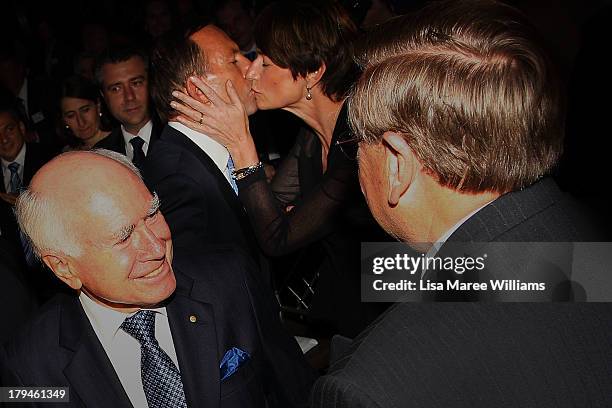 Australian Opposition Leader, Tony Abbott is kissed by his wife Margie Abbott and congratulated by John Howard during a fundraiser dinner in...