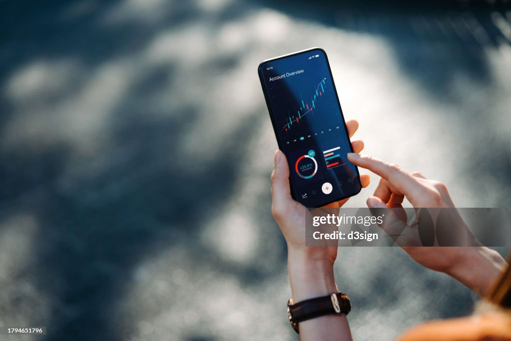 Businesswoman managing finance and investment online, reading financial trading data and making financial plan with smartphone. Online banking. Banking, investment and financial trading concept