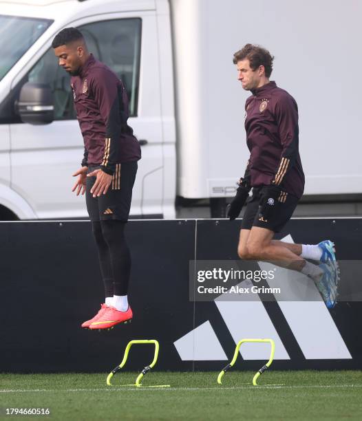 Benjamin Henrichs and Thomas Mueller jump during a training session of the German national football team at DFB-Campus on November 15, 2023 in...