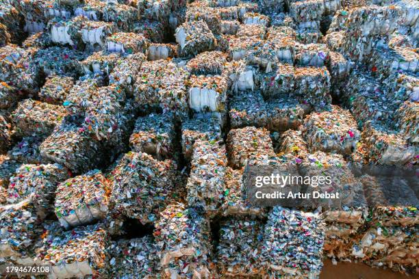 aerial view of a piles of crushed plastic bales stacking in a recycling plant. - smaltimento rifiuti foto e immagini stock