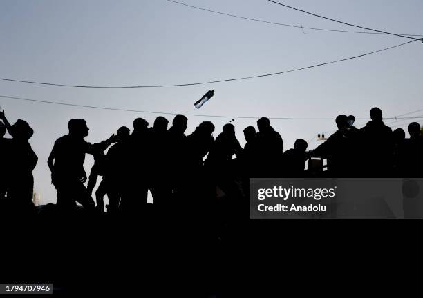 Palestinians flock around a truck carrying bottles of drinking water sent by the United Nations Children's Fund as the civilians experience water and...