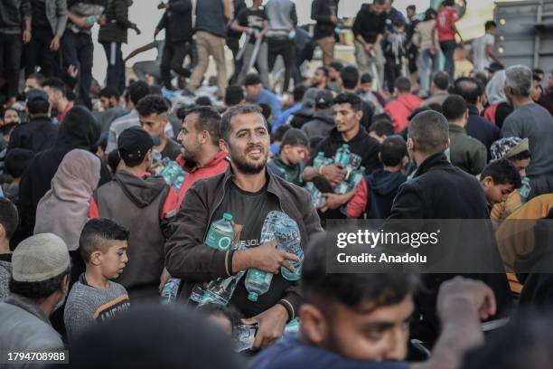 Palestinians flock around a truck carrying bottles of drinking water sent by the United Nations Children's Fund as the civilians experience water and...