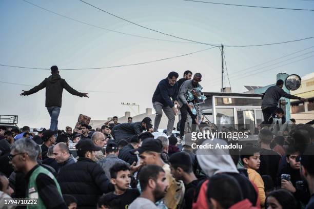 Palestinians flock around a truck carrying bottles of drinking water sent by the United Nations Children's Fund as the civilians experience water and...