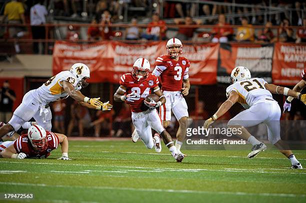 Running back Terrell Newby takes a hand off from quarterback Taylor Martinez of the Nebraska Cornhuskers during their game against the Wyoming...