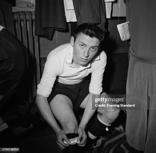 Chelsea Football Club youth player Barry Bridges tying up his socks in a locker room, June 13th 1956.