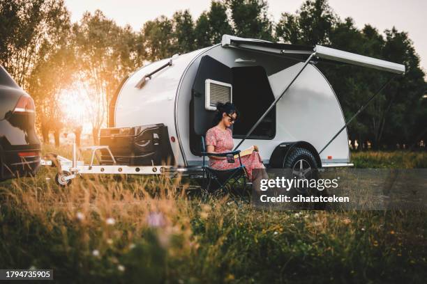 young woman relaxing with caravan balloons in cappadocia - camper trailer stock pictures, royalty-free photos & images