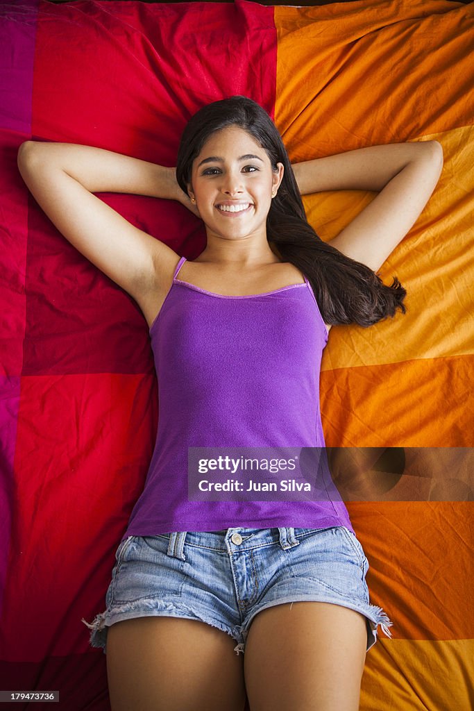 Teenage girl lying in bed smiling