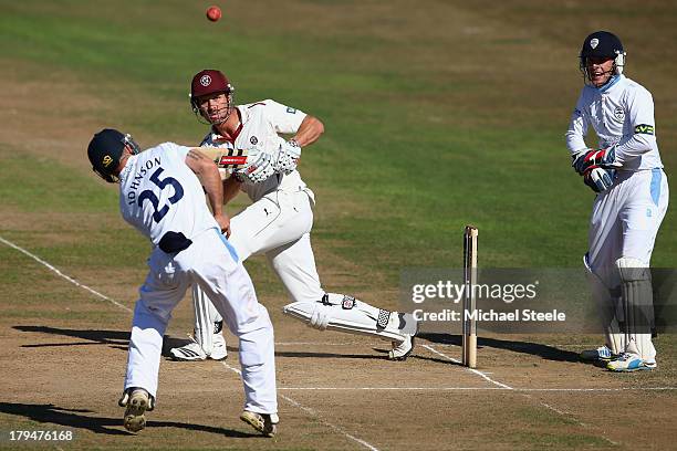 Nick Compton of Somerset sees his legside shot bounce off Richard Johnson of Derbyshire as wicketkeeper Thomas Poynton looks on during day two of the...