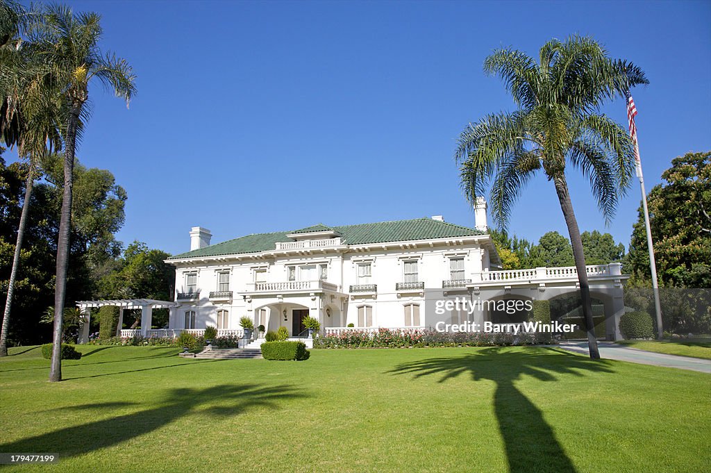 White building, green lawn and roof, blue sky