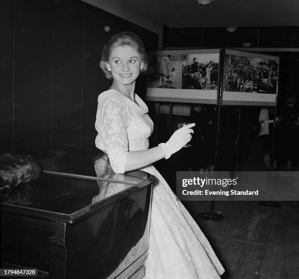 Actress Jill Ireland , wearing a white dress and gloves at an exhibition, September 28th 1956.