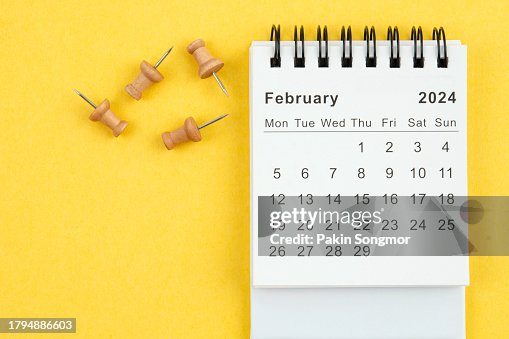 Desk Calendar 2024: February calendar is used to plan daily work and life with a push pin on a yellow paper background.
