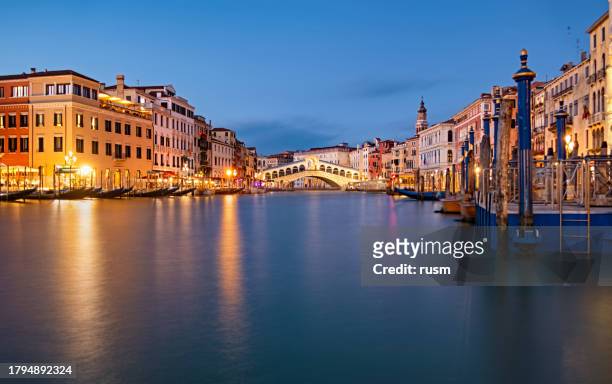 very long exposure evening shot of rialto bridge from grand canal water surface. venice, italy. - rialto bridge stock pictures, royalty-free photos & images