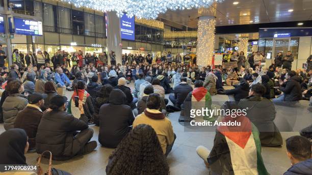 People take part in a sit-in protest to call for ceasefire in Gaza under Israeli attacks and denounce the Dutch government over its support for...