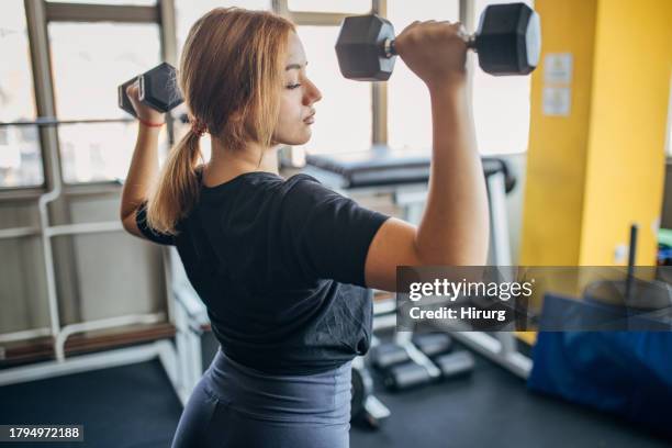 young woman training in gym - women's weightlifting stock pictures, royalty-free photos & images