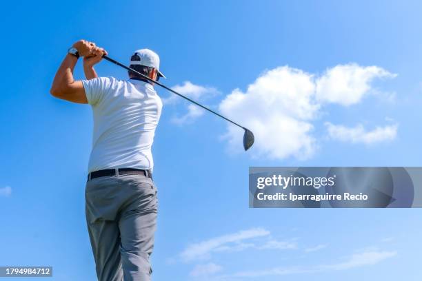 low angle rear view of a professional golfer swinging - golf swing from behind stock pictures, royalty-free photos & images