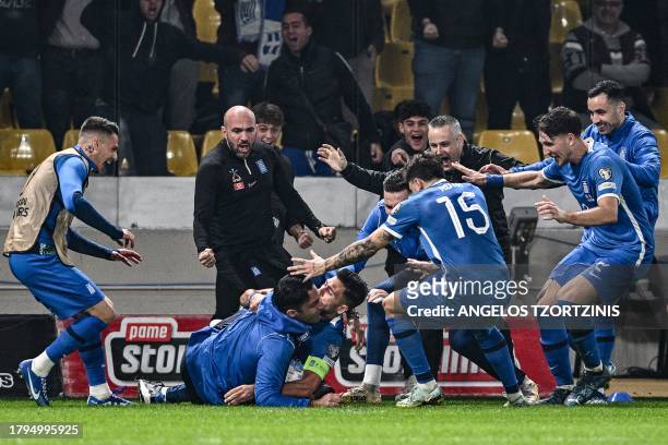 Greece's midfielder Tasos Bakasetas celebrates with teammates after scoring their first goal during the UEFA Euro 2024 Group B second leg qualifying...