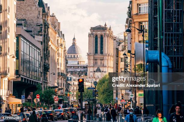 crowded paris street with pantheon and notre dame de paris in the distance, france - church color light paris stockfoto's en -beelden