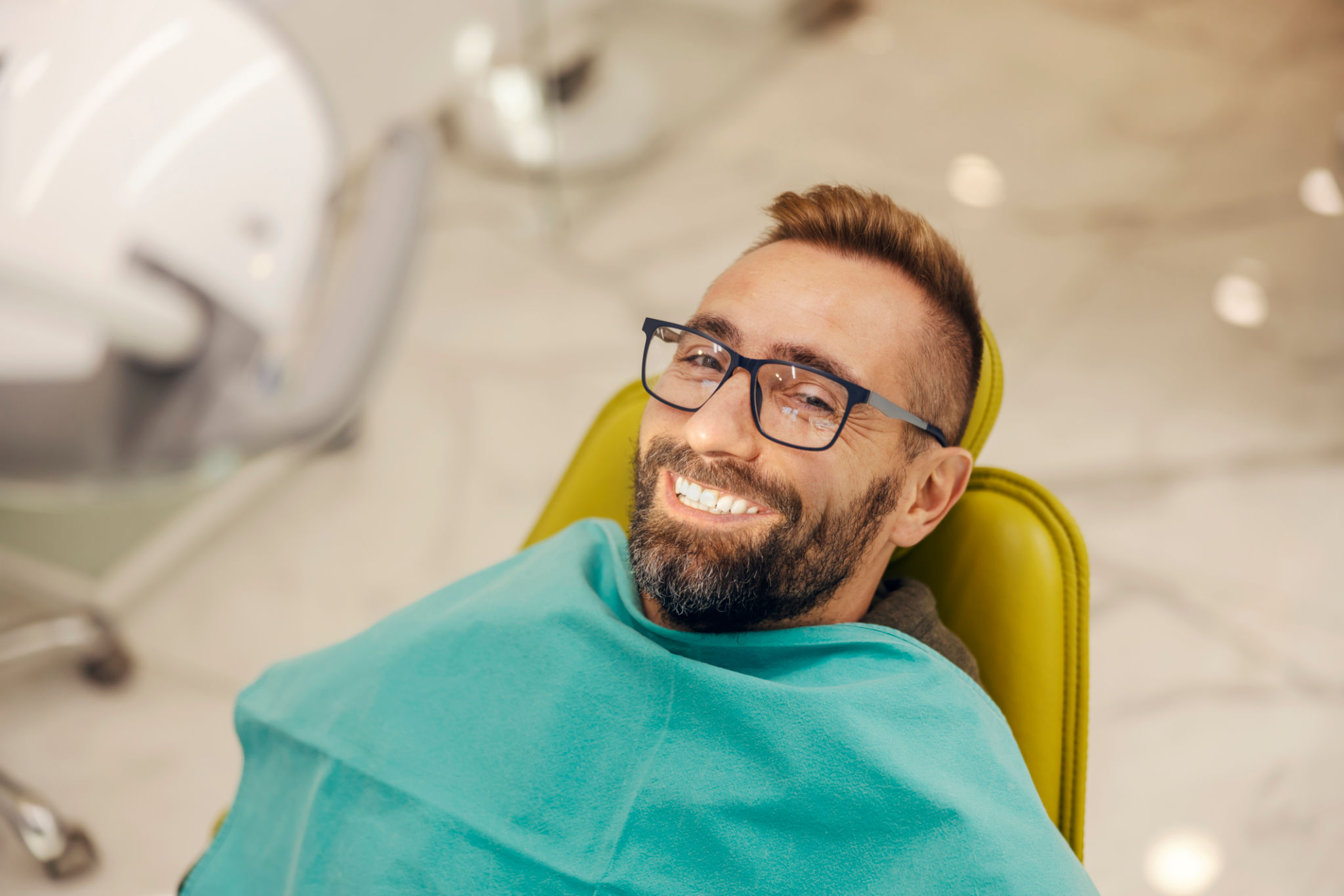 Portrait of a patient sitting at dentist office in chair with perfect smile. Portrait of a patient sitting at dentist office in chair with perfect smile.