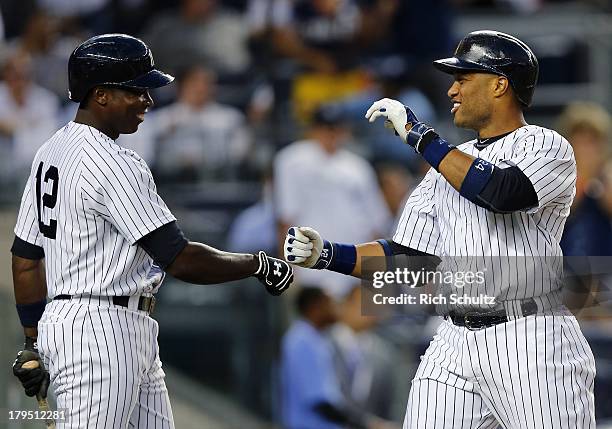 Robinson Cano of the New York Yankees is congratulated by teammate Alfonso Soriano after hitting a solo home run in the first inning against the...