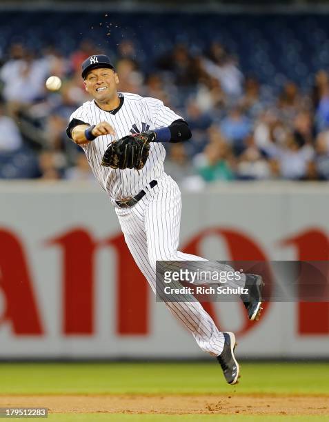 Shortstop Derek Jeter of the New York Yankees makes a throw to first base to get Jeff Keppinger of the Chicago White Sox to end the first inning in a...