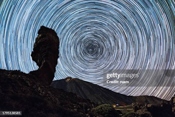 sternpfade über dem vulkan teide und den felsen los roques de garcia, teide nationalpark, teneriffa, kanarische inseln, spanien. - weltraum und astronomie stock-fotos und bilder