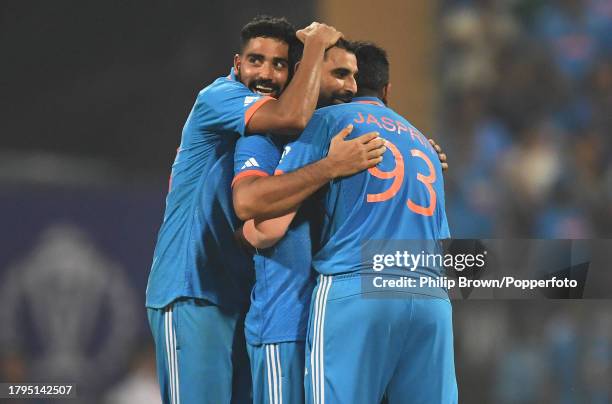Mohammed Siraj , Mohammed Shami and Jasprit Bumrah of India celebrate the dismissal of Dary Mitchell during the ICC Men's Cricket World Cup India...
