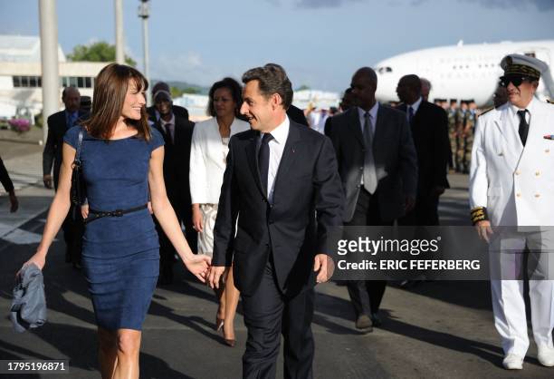 French President Nicolas Sarkozy and his wife Carla Bruni-Sarkozy arrive at Lamentin airport on January 7 2011 in Fort-de-France, on the French...