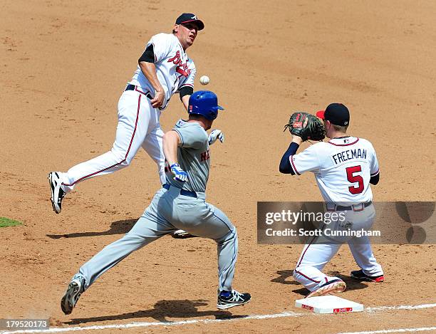 Daniel Murphy of the New York Mets beats the throw to first base by Freddy Garcia of the Atlanta Braves to Freddie Freeman of the Braves at Turner...