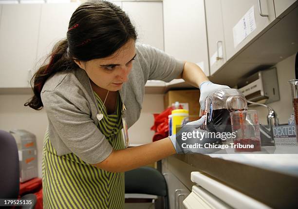 Graduate research assistant Kayla Smith mixes cranberry juice with alcohol for a test driver, August 20 at the National Advanced Driving Simulator at...