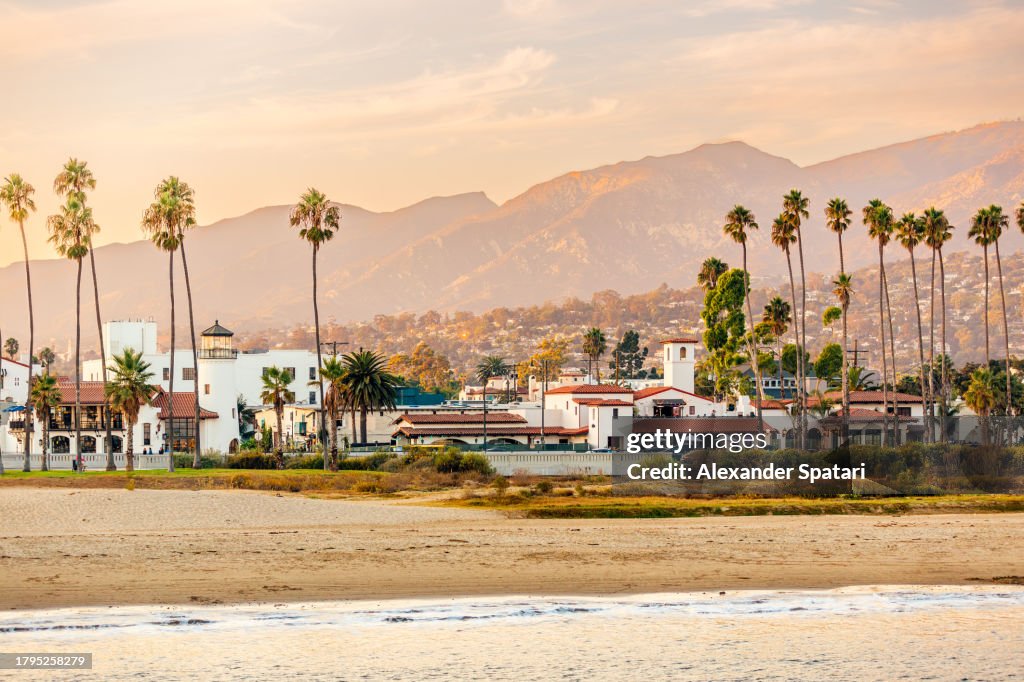 Santa Barbara beach with palm trees and city skyline at sunset, California, USA