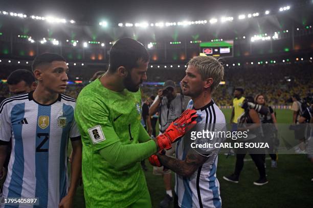 Brazil's goalkeeper Alisson talks with Argentina's midfielder Rodrigo De Paul after clashes erupted on the stands with fans and the Brazilian police...