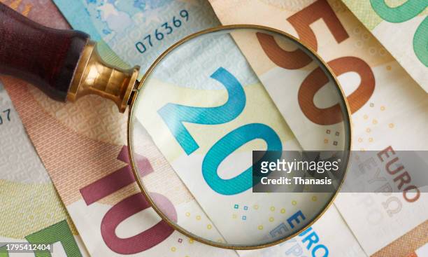 eu currency, euro banknotes and a magnifying glass - euro money stock pictures, royalty-free photos & images