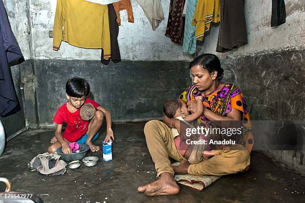 Beauty Begum is breastfeeding her child during her lunch break on May 23, 2013 in Chittagong, Bangladesh. She and her husband work in garment factory...