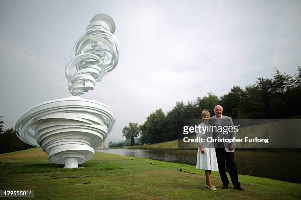 The Duke and Duchess of Devonshire pose beside a sculpture titled 'Cyclone Twist' by Alice Aycock displayed in the grounds of Chatsworth House as...