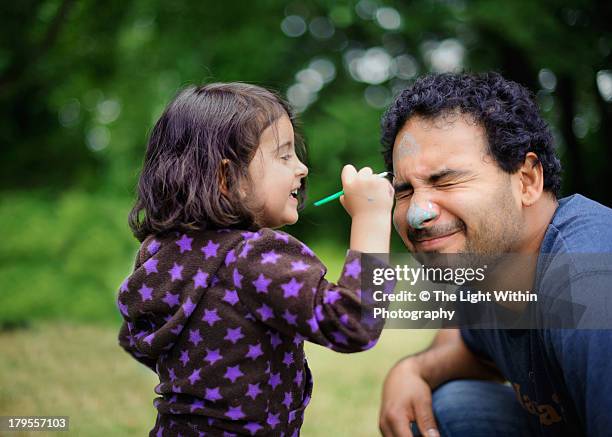 daughter paints daddy's face - face painting kids stock-fotos und bilder