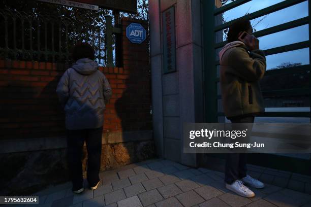 Mother prays as her daughter takes the College Scholastic Ability Test in front of the main gate of an examination school on November 16, 2023 in...