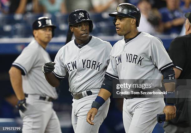 Alfonso Soriano of the New York Yankees celebrates his three-run home run in the first inning with Robinson Cano as Alex Rodriguez walks to home...