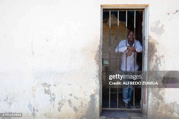 An inmate stands behind a grill in the general prison of Maputo on November 6, 2023. A large pilot of an artificial intelligence programme that has...