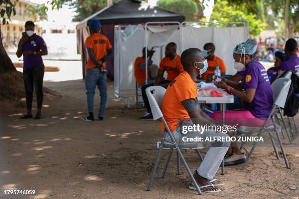 Medical staff members perform a medical checkup on an inmate as others wait for their turn at the general prison in Maputo on November 6, 2023. A...