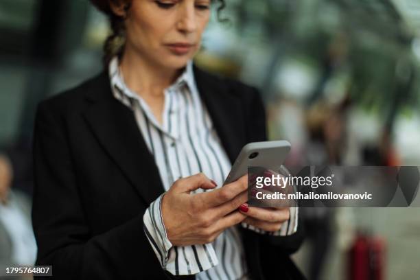 texting on a smartphone - businesswoman airport stock pictures, royalty-free photos & images