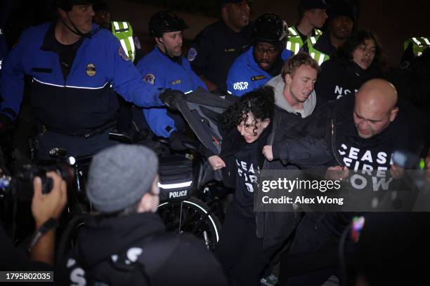 Members of U.S. Capitol Police pull protesters away from the headquarters of the Democratic National Committee during a demonstration against the war...