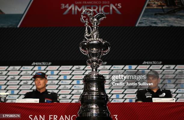 The America's Cup trophy is displayed during a news conference with Emirates Team New Zealand skipper Dean Barker and Oracle Team USA skipper James...