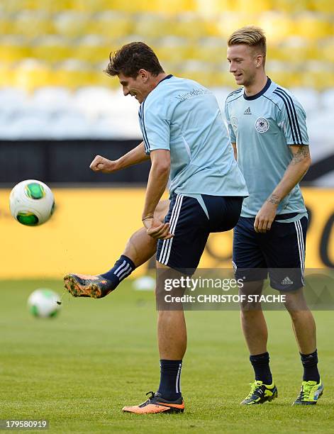 Germany's striker Mario Gomez plays the ball beside Germany's midfielder Marco Reus during the final training's session of the German national...