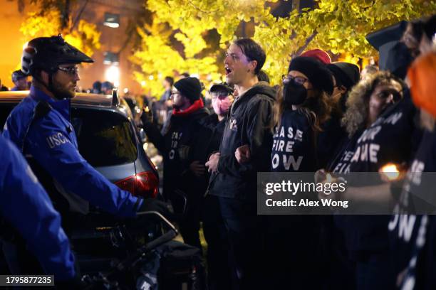 Members of U.S. Capitol Police and protesters stand off outside the headquarters of the Democratic National Committee during a demonstration against...