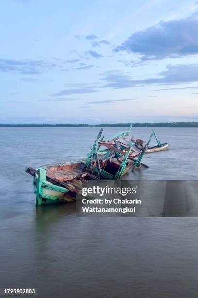 broken fishing boat sinking in the water. - capsizing stock pictures, royalty-free photos & images